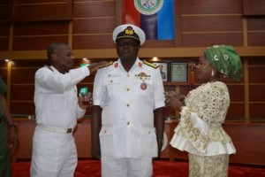 Commander Ngatuwa being decorated by the CDS Rep Rear Admiral Apochi Suleiman and assisted by Mrs Ngatuwa